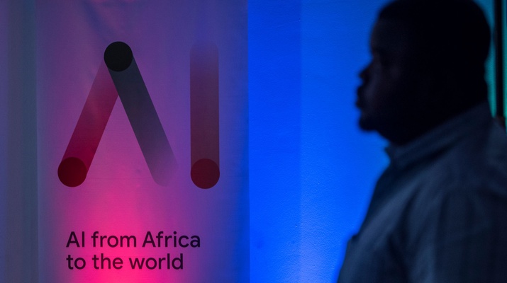 Ein Mann steht vor einem Banner der ersten Messe für künstliche Intelligenz in Afrika.